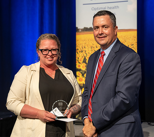 Kansas Hospital Association President Chad Austin presents a Heart of Health Care Award to Coffey County Hospital Laboratory Assistant Holly Peters during the Association’s annual award luncheon in Kansas City on September 5. 